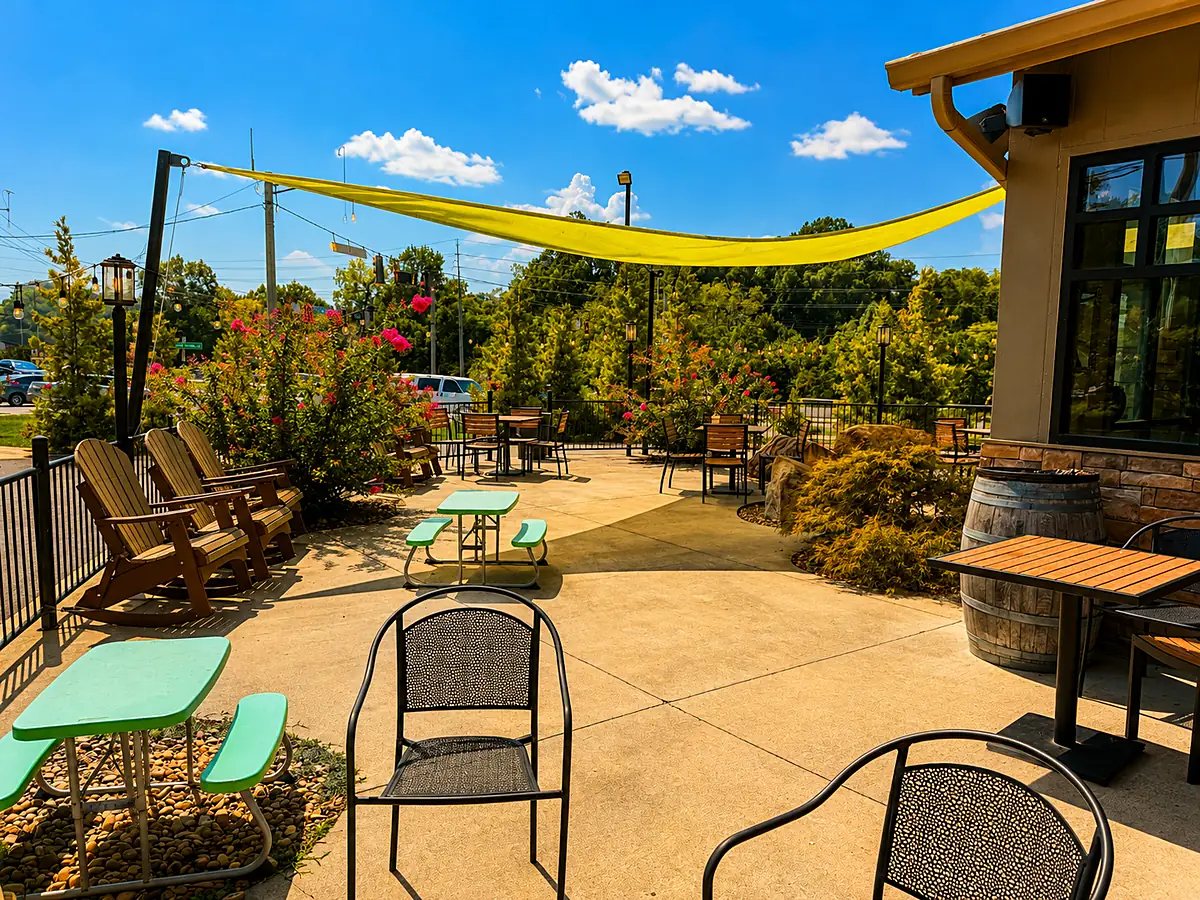 The sunny patio at Smoky Mountain Espresso with rocking chairs and picnic tables under a shade sail