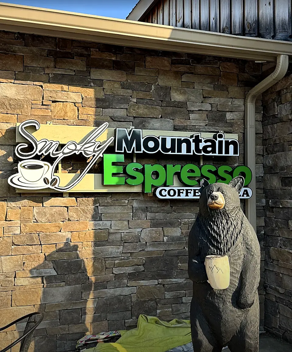 The carved black bear holding a coffee cup under the Smoky Mountain Espresso sign